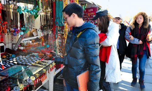 圖為近日，來(lái)自廣東的游客在選購(gòu)紀(jì)念品。