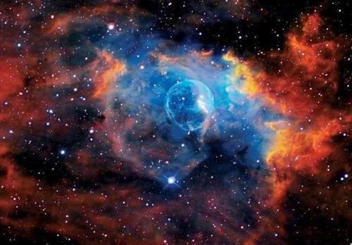 這是著名的“氣泡星云”（Bubble Nebula），這是一個(gè)灰塵氣體星云，其直徑為10光年，相當(dāng)于60萬億英里。氣泡星云是由一顆恒星燃燒時(shí)的脫離物質(zhì)構(gòu)成，恒星燃燒時(shí)可釋放出太陽數(shù)百倍亮度的光芒。該星云距離地球11000光年，位于仙后星座。