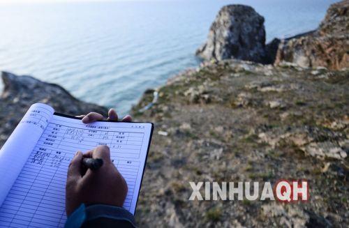 青海湖國家級自然保護區(qū)管理局工作人員在記錄鳥類觀測數(shù)據(jù)。新華社　張宏祥　攝