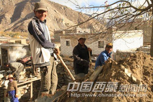 正在蓋房子的村民熱情地招呼記者拍照。