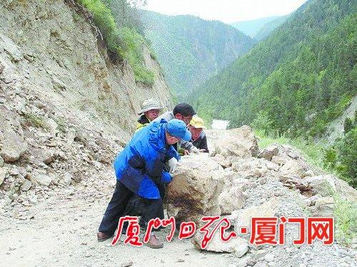 援藏干部下鄉(xiāng)調(diào)研途中遇到滾石墜落，合力將滾石推開為汽車開道。（肖衛(wèi)東 供圖）