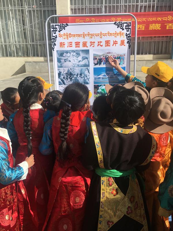集體活動結(jié)束后，各班排隊參觀新舊西藏對比圖片展。圖為五年級的歐珠旺姆和央青措姆擔任解說員，分別為同學們講解新舊西藏圖片。.JPG