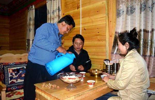 尼瑪正為遠道而來的游客斟滿酥油茶.JPG.jpg