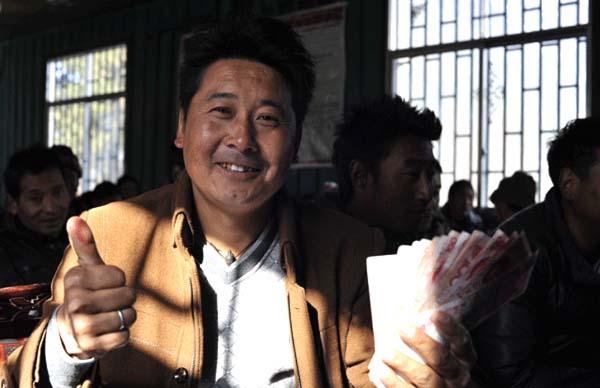 崗巴村一村民領(lǐng)到生態(tài)補償金后，豎起大拇指夸贊黨和國家的生態(tài)環(huán)保政策 本報記者 麥正偉 攝.jpg